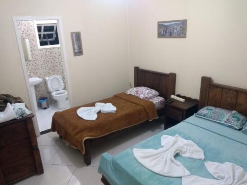a room with two beds with towels on them at Cafe Preto Pousada e Bistrô in Mucugê