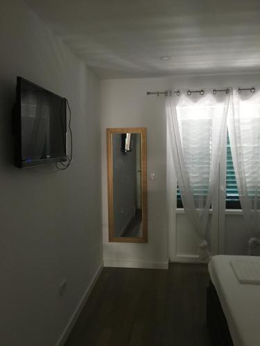 a bedroom with a mirror and a television on the wall at Villa Godinovic in Hvar
