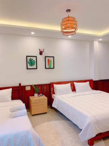 a bedroom with two beds and a chandelier at VIỆT Hostel in Hue