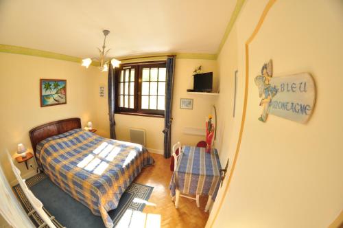 une chambre avec un lit, une table et une chaise dans l'établissement Hôtel-Logis La Coraline, à Gannat