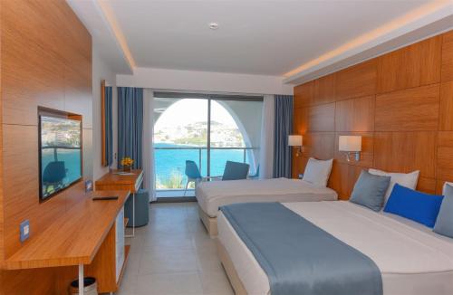 um quarto de hotel com duas camas e uma janela em INFINITY BY YELKEN AQUAPARK&RESORTS KUŞADASI em Kusadasi