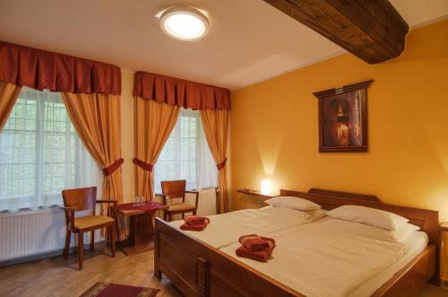 a bedroom with a large bed and a table and chairs at Pension Pod Radnicí in Český Krumlov
