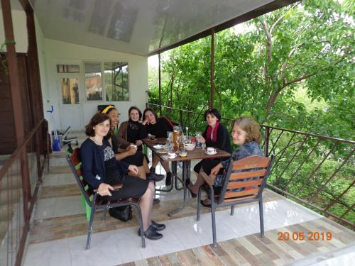a group of women sitting at a table on a porch at My home udabno in Udabno