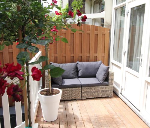 a couch on a porch with a potted plant at Apple Inn Hotel in Amsterdam