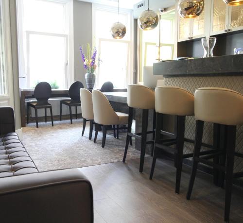 a bar with chairs and a table in a room at Apple Inn Hotel in Amsterdam