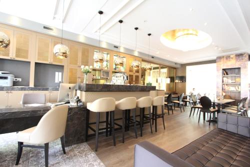 un restaurant avec un bar doté de tables et de chaises blanches dans l'établissement Apple Inn Hotel, à Amsterdam