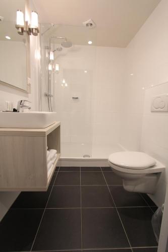 a bathroom with a shower and a toilet and a sink at Apple Inn Hotel in Amsterdam