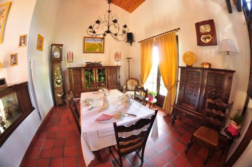 une salle à manger avec une table et des chaises blanches dans l'établissement Hôtel-Logis La Coraline, à Gannat