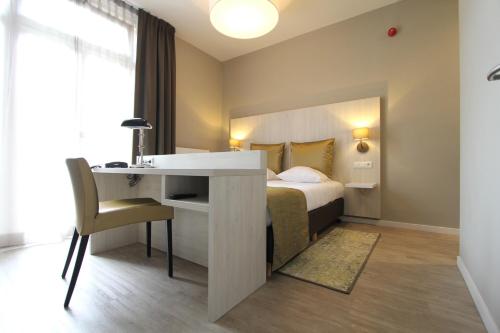 een hotelkamer met een bed en een bureau en een bed en een bureau bij Apple Inn Hotel in Amsterdam