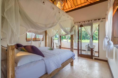 艾湄灣的住宿－加亞特里隱蔽綠洲度假屋，一间卧室配有一张带天蓬的大床