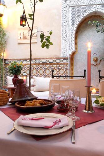 un tavolo con una candela e una tovaglia bianca di RIAD Redous a Marrakech
