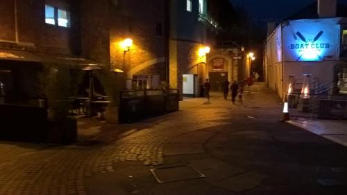 an empty street at night with people walking down the street at Apartment with Outside Patio and Car Space in Durham