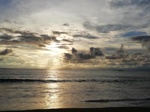 a sunset over the ocean with a cloudy sky at Garden of Heliconias Lodge in Drake