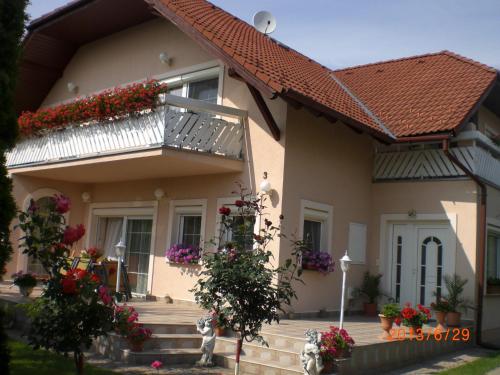 a house with a balcony with flowers on it at Majláth Vendégház in Bük