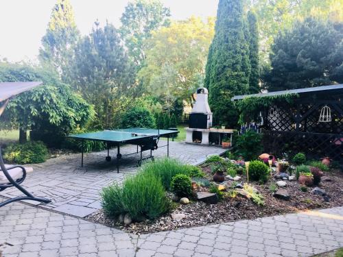 a patio with a ping pong table in a garden at Vila EVIO Třeboň in Třeboň