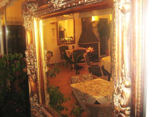 a mirror reflecting a living room with a table and chairs at La Fontaine in Vidauban