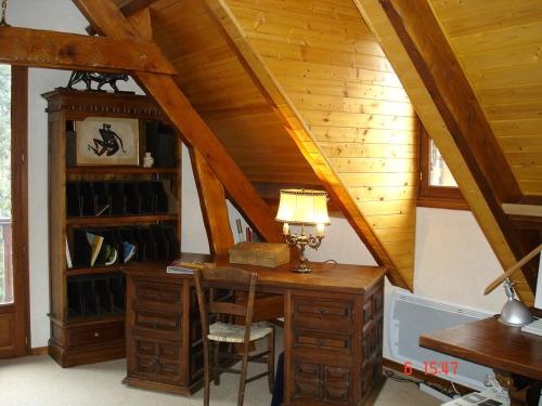 an attic room with a desk with a lamp at gîte Vallée des Nestes in Bareilles