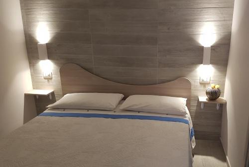 a bedroom with a bed with two lights on the wall at Case Vacanza Tony in Calatabiano