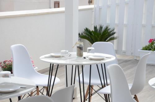 een witte tafel en witte stoelen op een balkon bij L'Angolo Dello Zio in San Vito lo Capo
