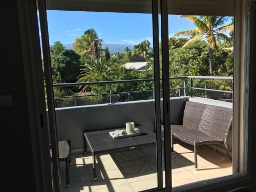 a balcony with a table and chairs and a view of the ocean at Studio Bis Cocoon in Saint-Gilles les Bains