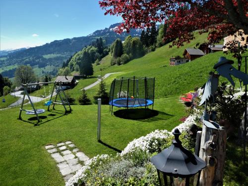 a park with two swings in the grass at Casa Fluretta in Flumserberg