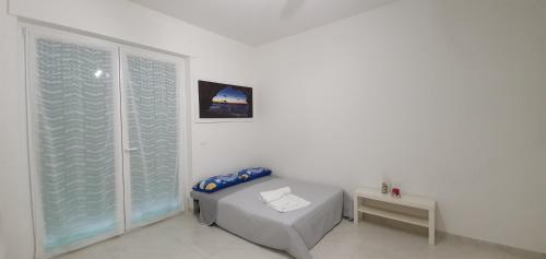 a white room with a bed and a window at La Dimora di Maja in Pescara