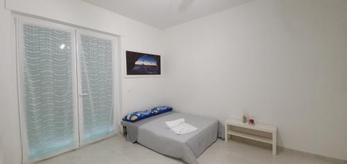 Camera bianca con letto e finestra di La Dimora di Maja a Pescara