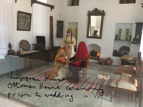 a woman standing in a living room with a glass table at Aphrodite Beachfront Apartment in Ghaziveran
