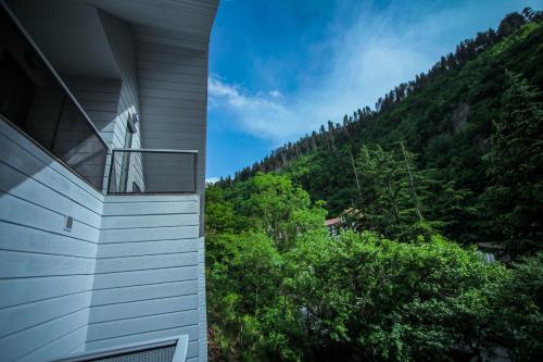 a balcony of a house with a mountain in the background at Borjomi UnderWood in Borjomi