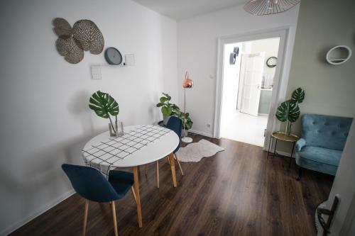a living room with a white table and blue chairs at Presso Pécs in Pécs