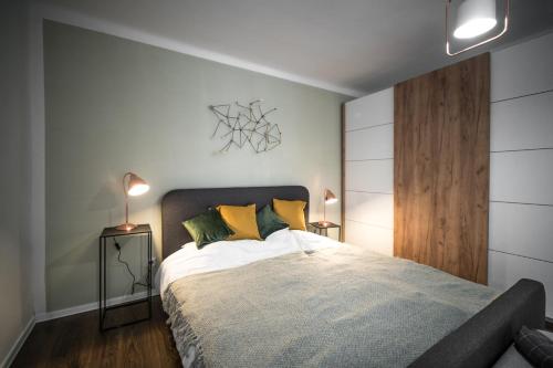 a bedroom with a large bed with yellow pillows at Presso Pécs in Pécs