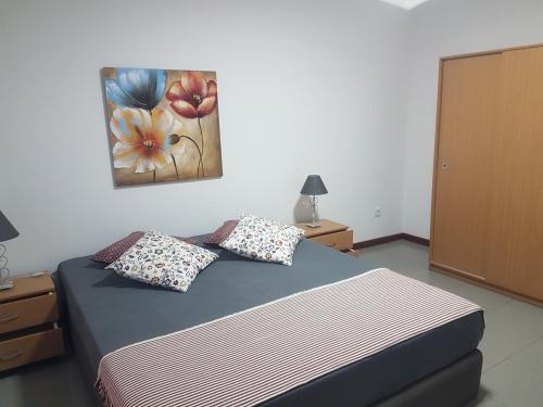 a bedroom with a bed and a painting on the wall at Beach and Mountain Paradise in Vila Praia de Âncora