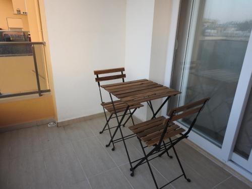 two chairs and a table in a room with a window at Alp Apartment in Mağusa