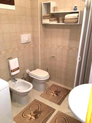 a bathroom with a toilet and a sink with starfish on the floor at La Casa del Sole in Marina di Pisticci