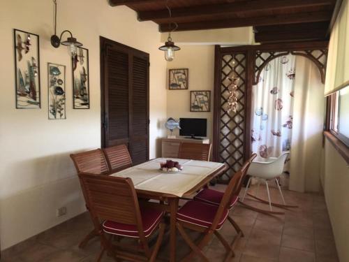 a dining room with a wooden table and chairs at La Casa del Sole in Marina di Pisticci