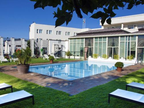 a swimming pool in front of a building at Hotel Oasis in Córdoba