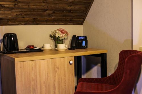a counter with a coffee maker and flowers on it at Borjomi UnderWood in Borjomi
