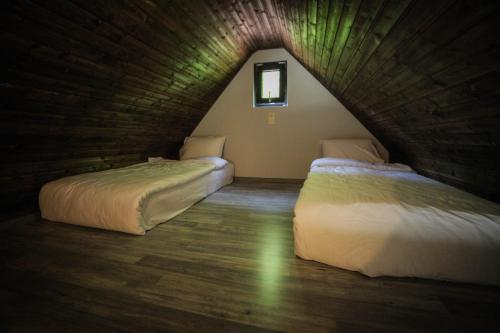 two beds in a room with a attic at Borjomi UnderWood in Borjomi
