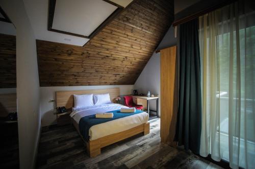 a bedroom with a bed with a brick wall at Borjomi UnderWood in Borjomi