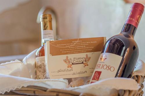 two bottles of wine sitting in a basket at Casa Bici in Chianni
