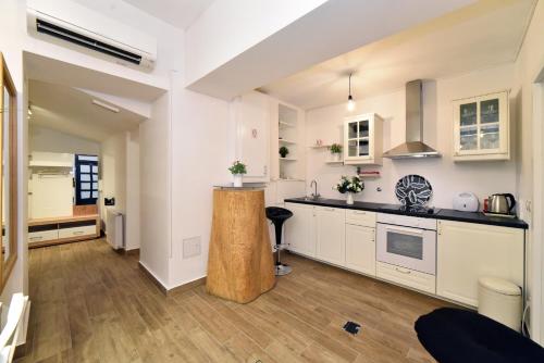 a kitchen with white cabinets and a wooden island at Ban Jelačić Apartment in Zagreb