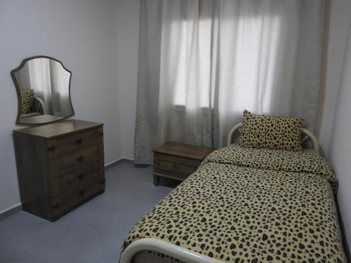 a bedroom with a bed and a mirror and a dresser at Alp Apartment in Famagusta