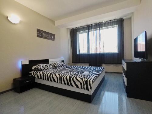 een slaapkamer met een bed met zebraprint en een raam bij Spacious and Bright Maisonette Varna Center in Varna