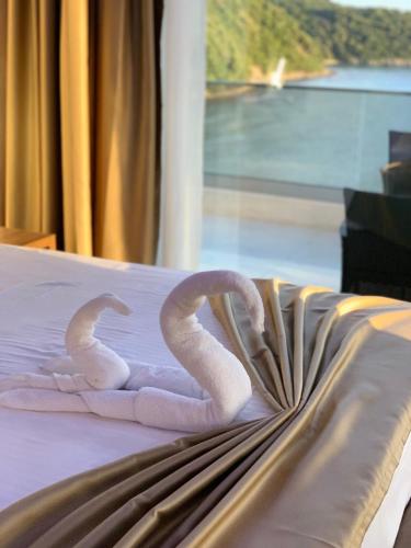 two towel snakes on a bed with a window at Apart Lux Beciragic in Dobra Voda