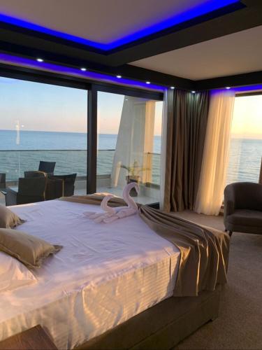 a large bed in a room with a view of the ocean at Apart Lux Beciragic in Dobra Voda