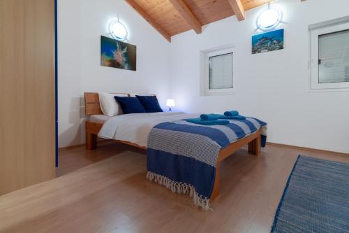 a bedroom with a bed with blue pillows on it at Guest house Otto in Punat