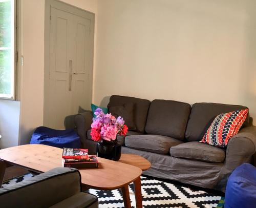 a living room with a brown couch and a table at La maison des amis in Nuits