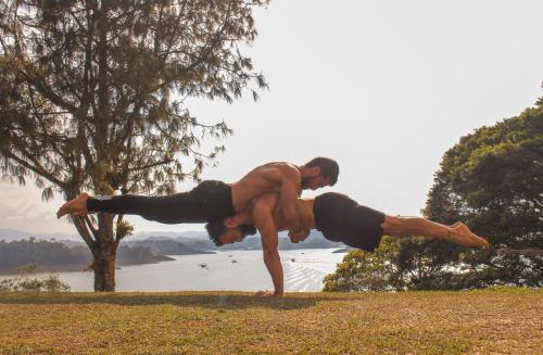 two men doing pushups in the grass near a lake at Casa Encuentro Ecolodge, Outdoor Gym and Yoga in Guatapé