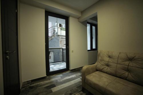 a living room with a couch and a window at Borjomi UnderWood in Borjomi
