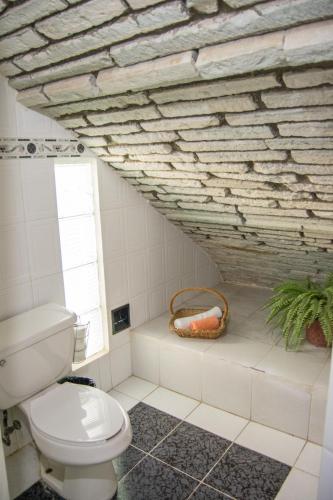 a bathroom with a toilet and a brick wall at Casa Lupita Hostel in Guanajuato